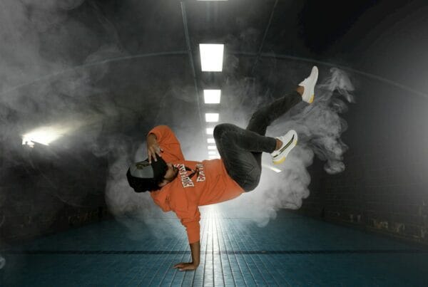 man in orange jacket and black pants